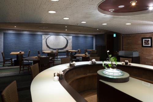 a restaurant with tables and chairs and a bar at Kanazawa New Grand Hotel Prestige in Kanazawa