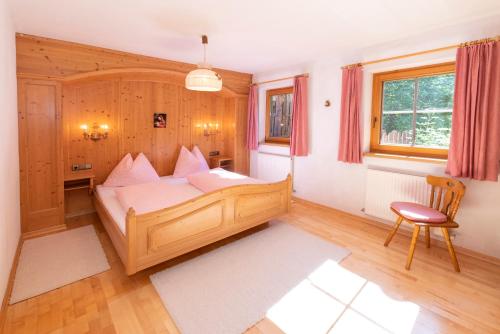 a bedroom with a wooden bed with pink pillows at Ferienhaus Schafstall in Alpbach