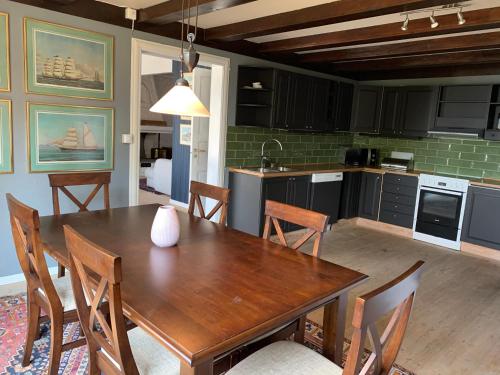 a kitchen and dining room with a wooden table and chairs at Moldegaard Farmhouse - Apartment A in Moldegard