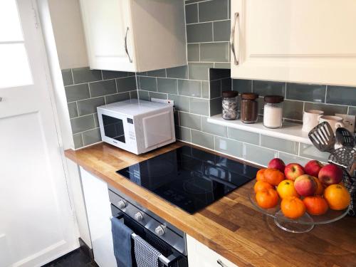 a kitchen with a bowl of fruit on a counter at Millie's Cottage in Finchingfield
