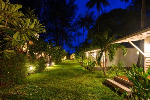 a yard with trees and a house at night at Wapi Resort in Ko Lipe