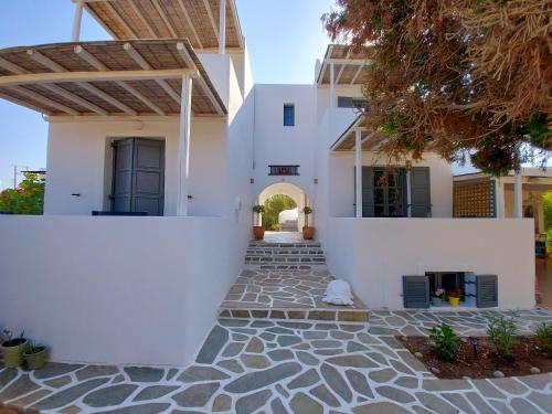 a house with white walls and a stone walkway at Villa Del Mar in Antiparos Town