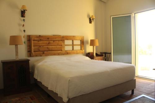 a bedroom with a large bed and a large window at Quinta da Soneca in Alandroal
