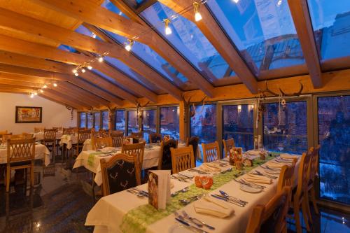 a dining room with tables and chairs and windows at Boutiquehotel Grandau in Sankt Gallenkirch