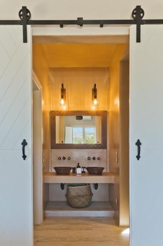 a bathroom with two sinks and a mirror at Lux View Suites in Kyra Panagia