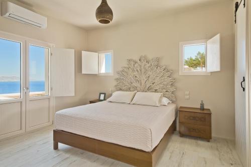 1 dormitorio con 1 cama y 2 ventanas en Lux View Suites en Kyra Panagia