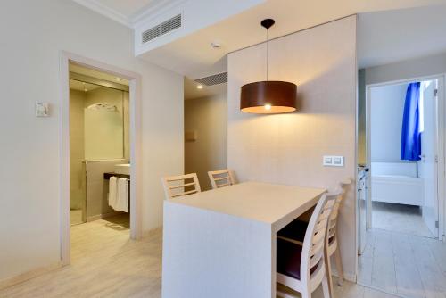 a kitchen and dining room with a table and chairs at Playa Garden Selection Hotel & Spa in Playa de Muro