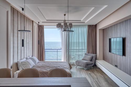 Maristella Marine Residense Hotel Apartment في أوديسا: غرفة معيشة مع سرير وإطلالة على المحيط