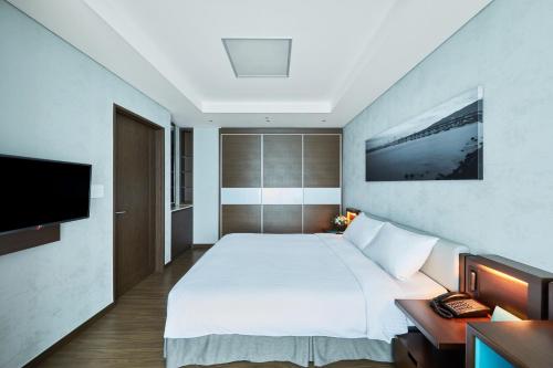 A bed or beds in a room at Felix by STX Hotel & Suite