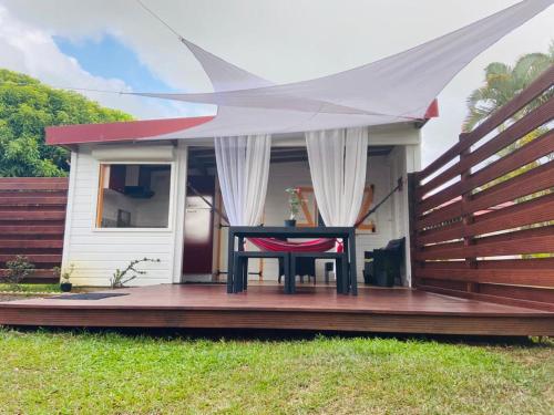 una mesa en una terraza con una tienda en una casa en padjembel, en Lamentin