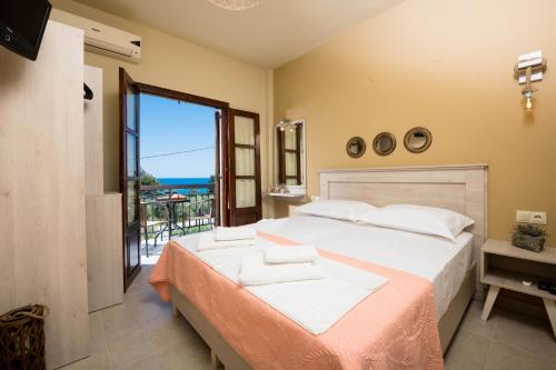 a bedroom with a bed with a view of the ocean at Pension Sotiria in Koinyra