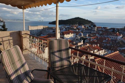 two chairs sitting on a balcony overlooking a city at Apartments Lucic in Dubrovnik