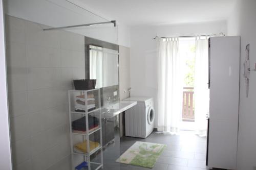 a white kitchen with a sink and a refrigerator at Ferienwohnung Domitian in Millstatt