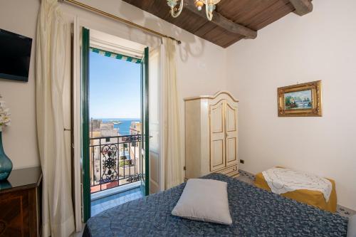 een slaapkamer met een bed en een groot raam bij Residenza Del Duca Rooms & Apartments in Amalfi