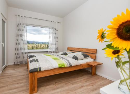 a bedroom with a bed and a window with a sunflower at Bauernhof Koch in Edingen-Neckarhausen