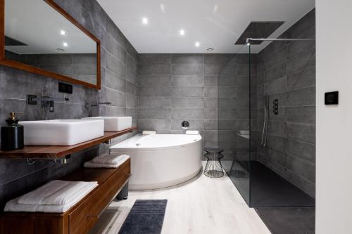 uma casa de banho com uma banheira, um lavatório e um chuveiro em Magnifique Loft , Proche Métro Lille em Croix