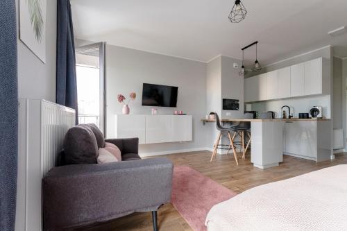 a living room with a couch and a kitchen at Apartament Alfa with free parking in Poznań