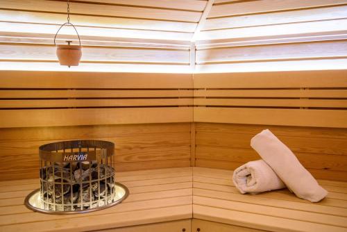 a sauna with a towel and a cage of rocks at Apartments Marconio Wellness Club in Belgrade