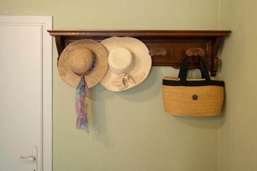 two hats and a purse are hanging on a wall at Villa Barbara in Santa Luce