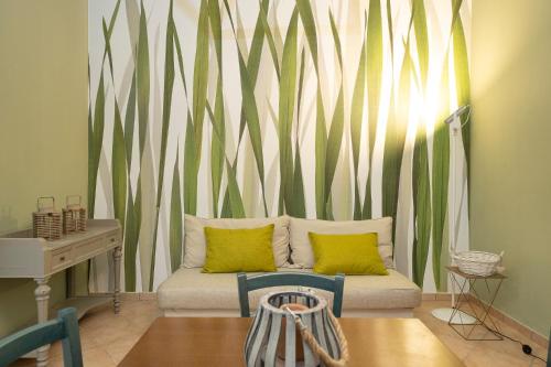 a living room with a couch with a green and white wall at Villa Barbara in Santa Luce
