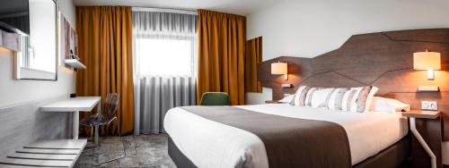 a hotel room with a large bed and a window at Mercure Belfort Centre in Belfort
