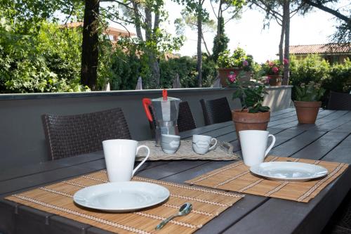 a wooden table with two plates and cups on it at Villa Barbara in Santa Luce