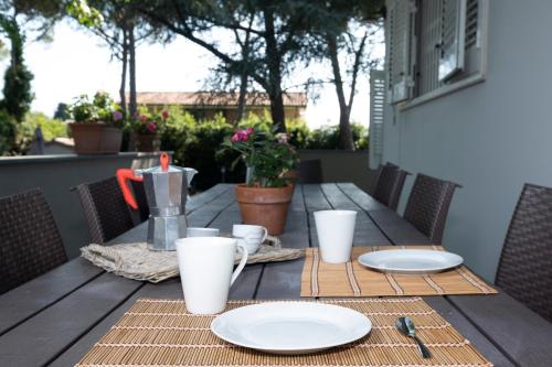 a wooden table with plates and utensils on it at Villa Barbara in Santa Luce