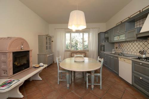 a kitchen with a table and a sink and a stove at Villa Barbara in Santa Luce