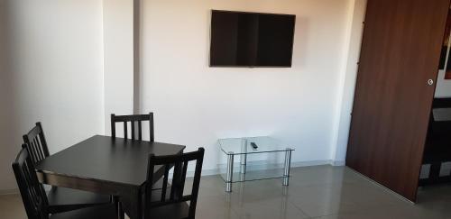 a dining room with a table and a television on a wall at Jetadrenaline Watersports Club in Rewa