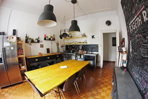 Il comprend une cuisine avec une table en bois et un réfrigérateur. dans l'établissement Coliving Trastevere, à Rome