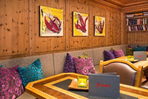 a restaurant with a table and pillows on a couch at Boutiquehotel Grandau in Sankt Gallenkirch
