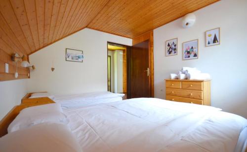 1 dormitorio con cama blanca y techo de madera en Apartma Židan, en Kranjska Gora