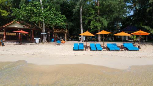 a group of chairs and umbrellas on a beach at Wapi Resort in Ko Lipe