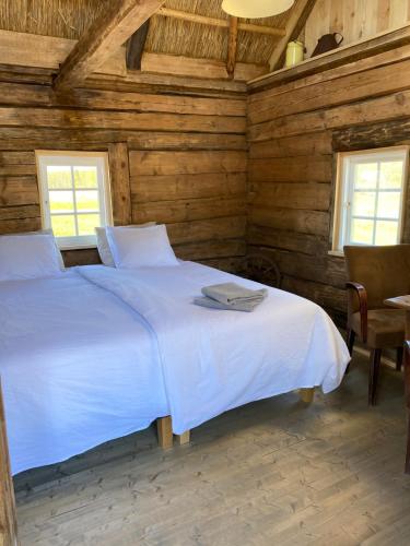 a bedroom with a white bed in a wooden room at Jaagu-Mihkli Muhu Island in Ridasi
