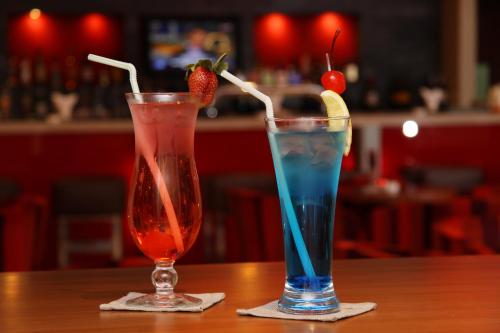 two cocktails sitting on a table in a bar at Crowne Plaza Sohar by IHG in Sohar