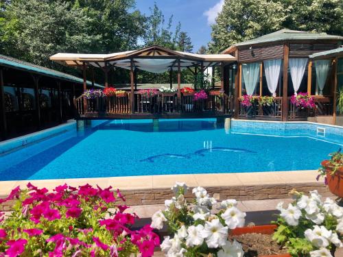 una piscina con gazebo e fiori di Family Hotel Residence a Dobrič