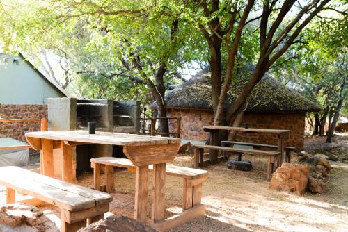 a group of picnic tables and benches in front of a building at Shala Mushe Tented Camp & Camp in Bela-Bela