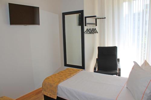 a bedroom with a bed and a mirror and a chair at Vivacity Porto - Rooms & Apartments in Porto