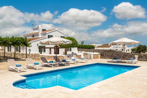 a villa with a swimming pool and chairs and a house at Llucasaldentet in Alaior