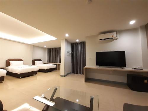 uma grande sala de estar com televisão e sofá em Zleep D Hotel em Udon Thani