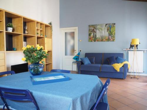 sala de estar con mesa y sofá azul en Casa Mariposa, en Desenzano del Garda