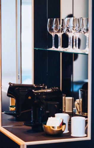 a counter with wine glasses on a shelf at Hotel Brandan in Tórshavn