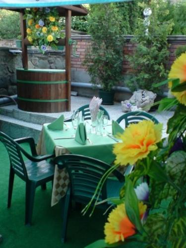 a green table and chairs and flowers on a patio at Darling Hotel in Sofia
