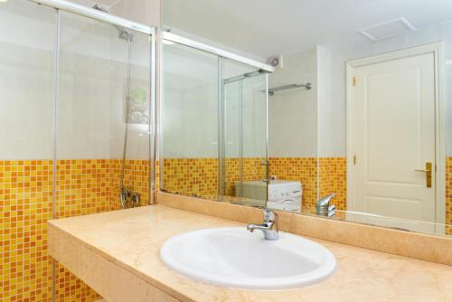 un bagno con lavandino e doccia in vetro di El Jasmine a Corralejo
