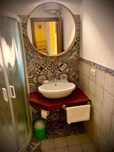 a bathroom with a sink and a mirror at Residenze L'Isola Surf House in Porto Pollo
