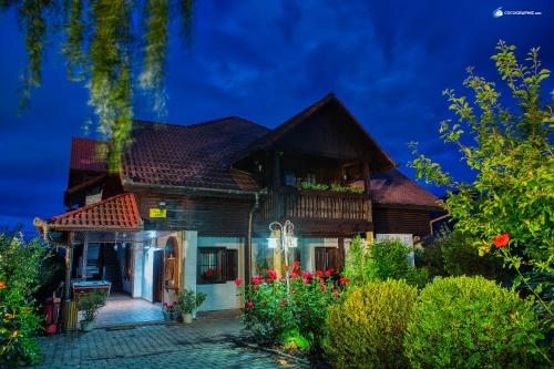 a house at night with flowers in the yard at Pensiunea Apfelhaus in Cisnadioara