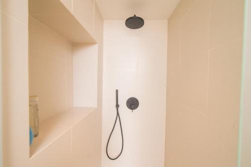 um chuveiro numa casa de banho com uma parede branca em Liston Boutique Suites by CorfuEscapes em Corfu Town