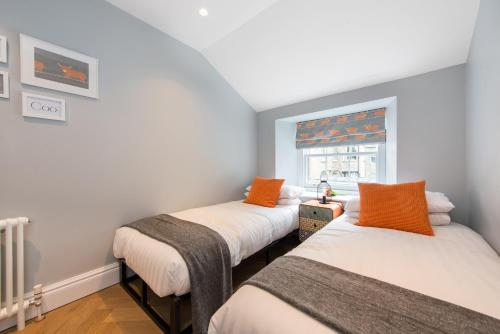 two beds in a room with a window at City Centre, Newly Refurbished Stylish Apartment in Edinburgh