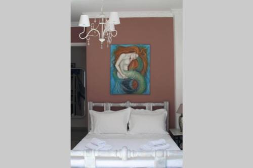 sypialnia z łóżkiem z obrazem na ścianie w obiekcie Marys Art and Cultural House 100meters from the beach w miejscowości Amoudara