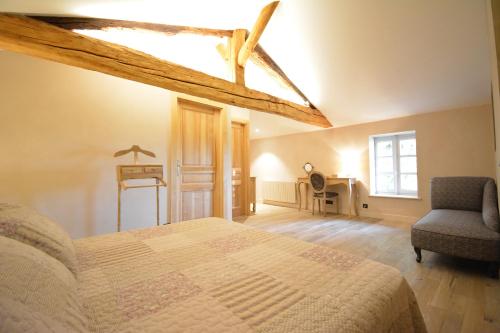 a bedroom with a bed and a chair and a desk at LE BEL AIR DE SAINT JEAN in Belleville-en-Beaujolais